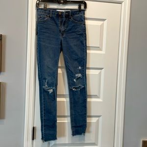 Medium wash distressed jeans.